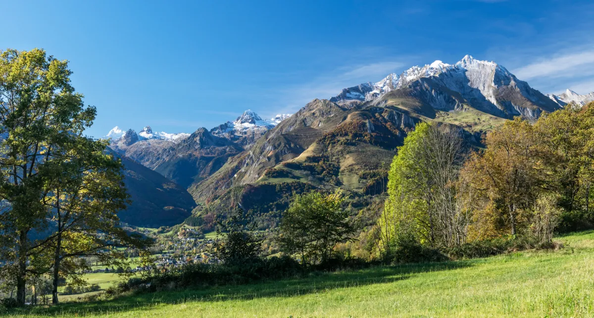 Une vallée verdoyante des Pyrénées dominée par un sommet enneigé